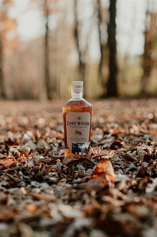 Lost Woods whiskey bottle shown in the Minnesota woods. 