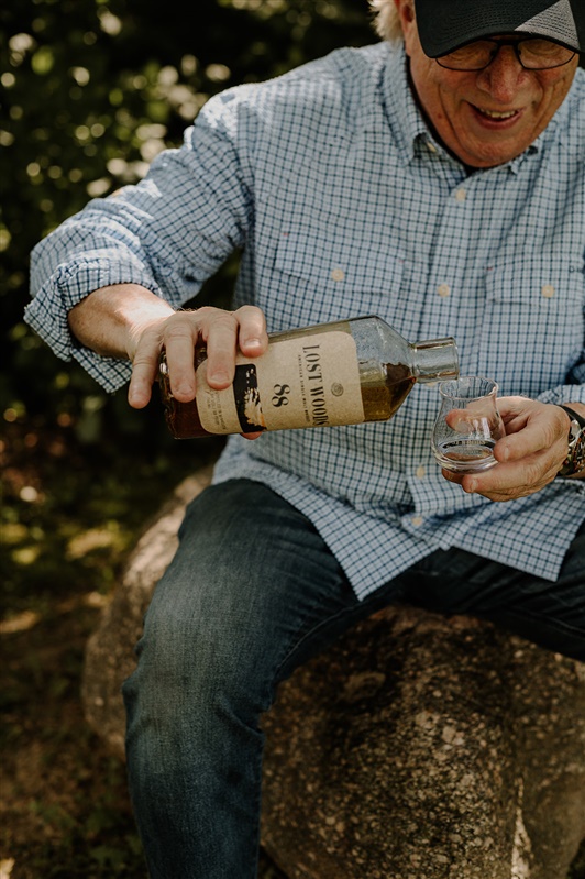 Tom Schaeppi and a Lost Woods bottle in the woods of Minnesota.